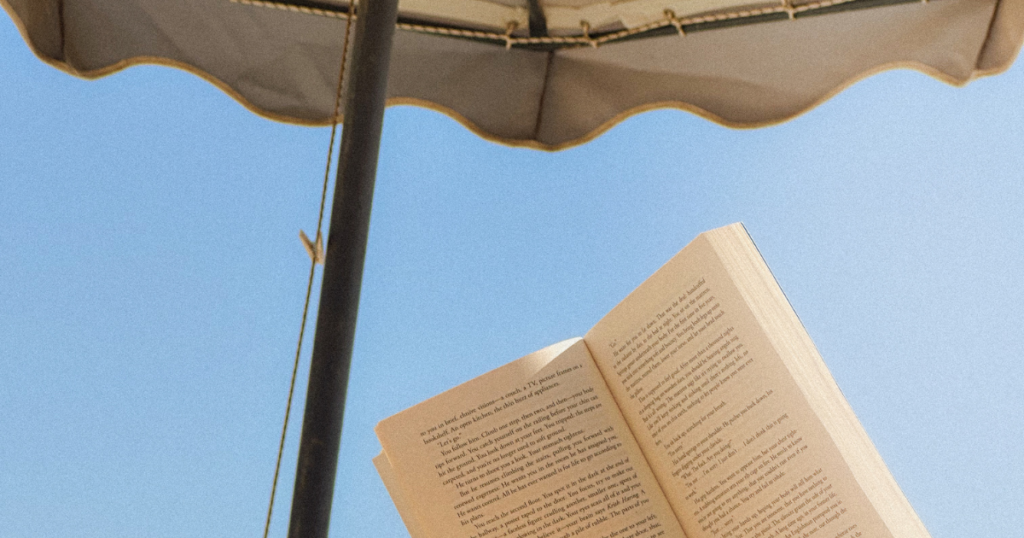 reading under a blue sky and umbrella