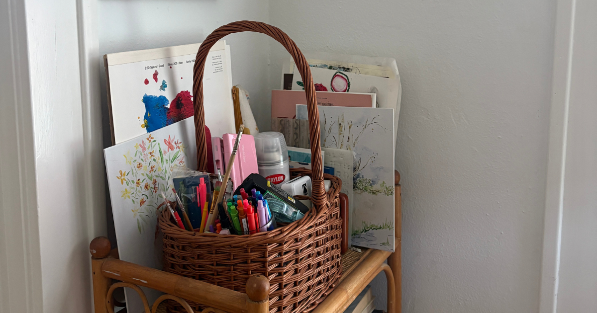 a basket in the corner with art and supplies in and around it